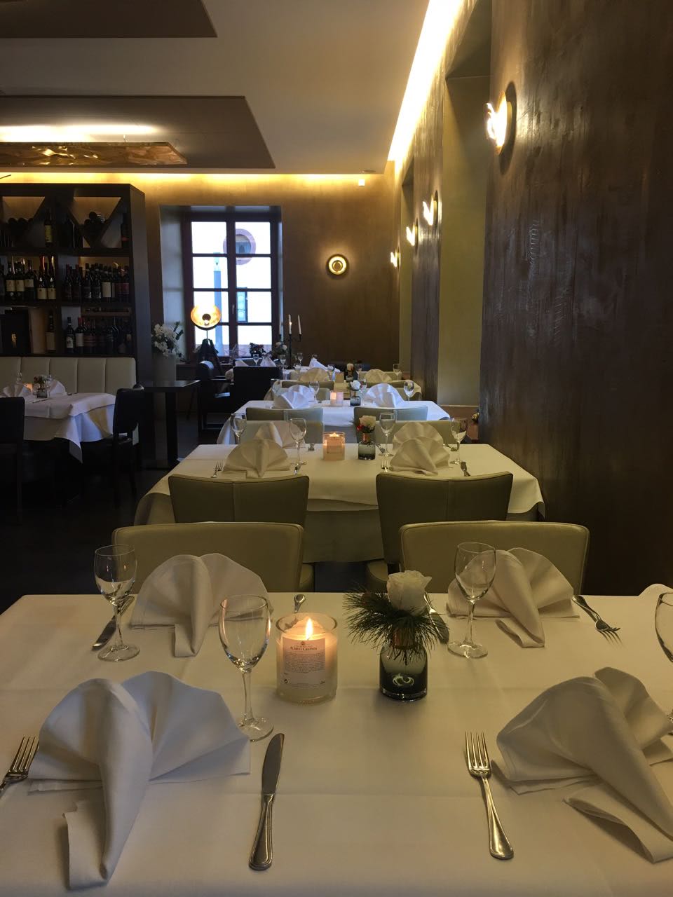 Eleganter Tisch vor der Vinothek mit Kerze und weißer Rose